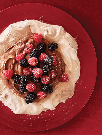 Pavlova garnie de crème au chocolat et de petits fruits