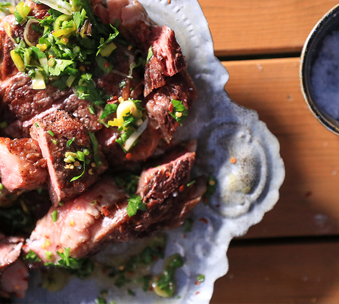 Biftecks grillés nappés d'une sauce chimichurri aux poireaux et servis avec une poêlée de champignons maitake