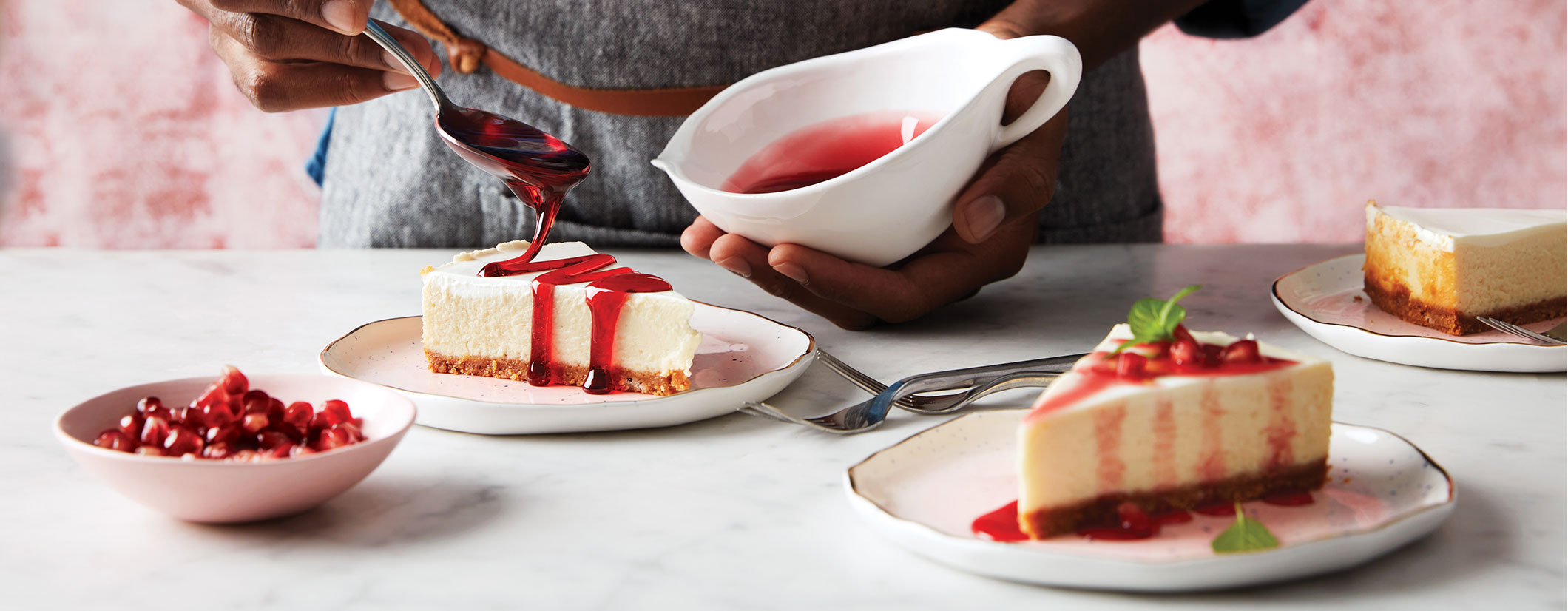 Image of hands pouring cranberry topping over cheesecake