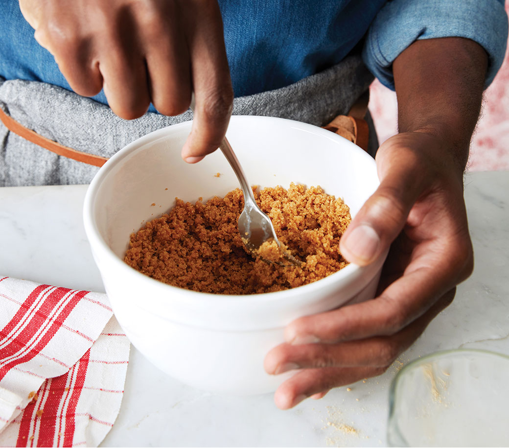 image of hands stirring crumbs with buttter