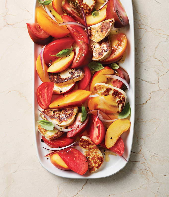 Salade de tomates et de nectarines garnie de halloumi poêlé et de basilic