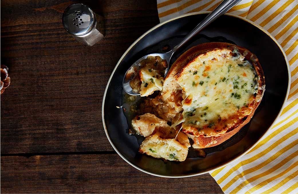 Soupe à l’oignon richement gratinée servie dans un bol en pain