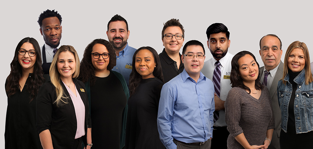 Photo of 14 smiling diverse employees from all areas of the business