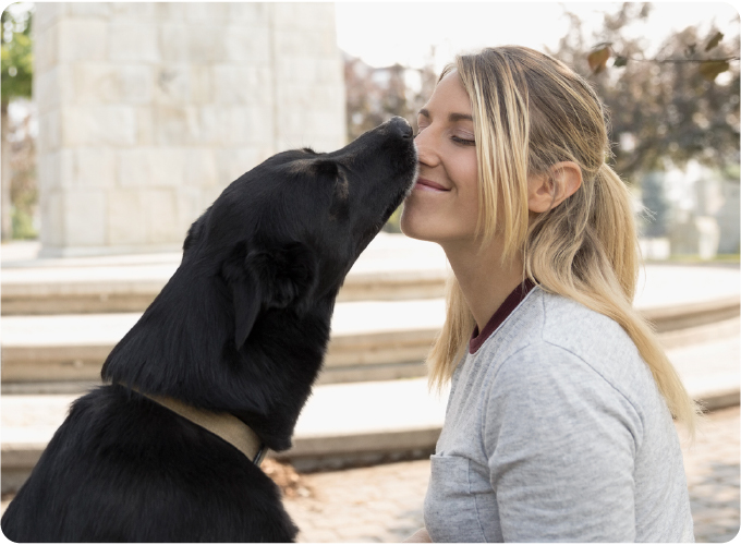 Une femme faisant un câlin à un chien, illustrant le concept d’un avenir heureux.