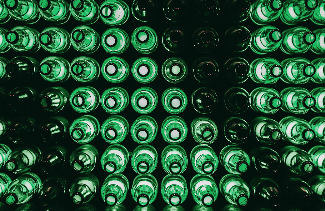  top down view of rows of empty green beer bottles 